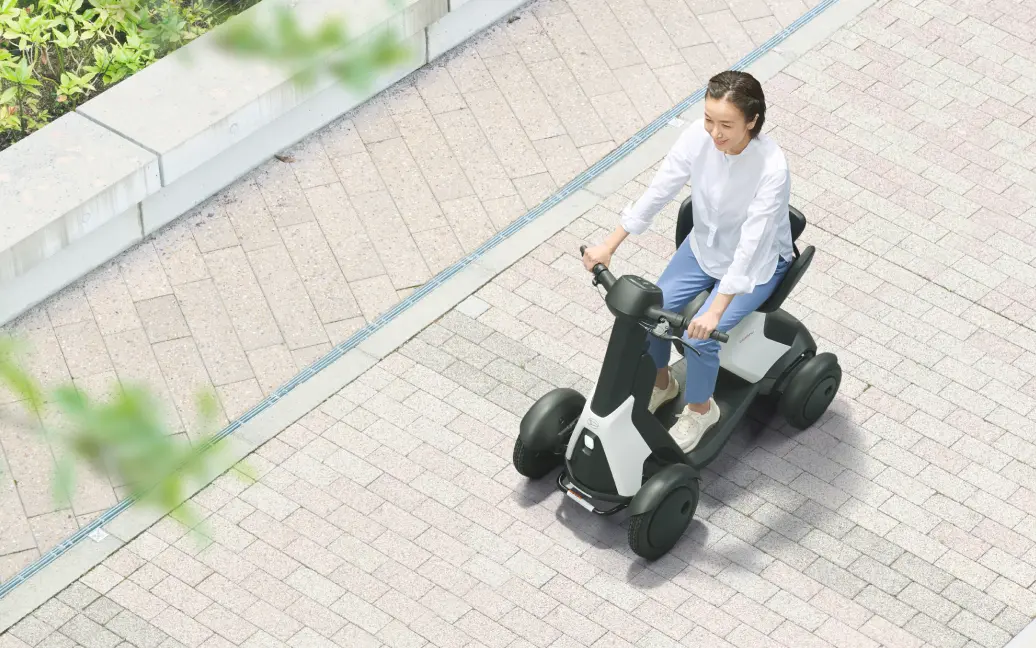 画像：歩道でe-SNEAKERでの移動を楽しむ女性
