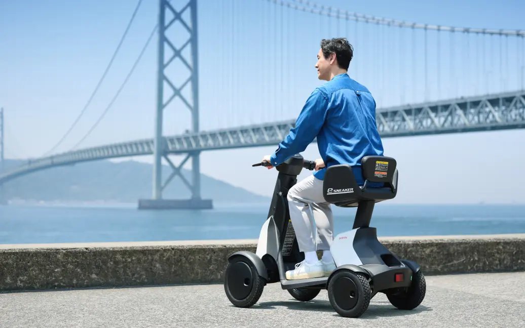画像：海辺の歩道でe-SNEAKERに乗る男性