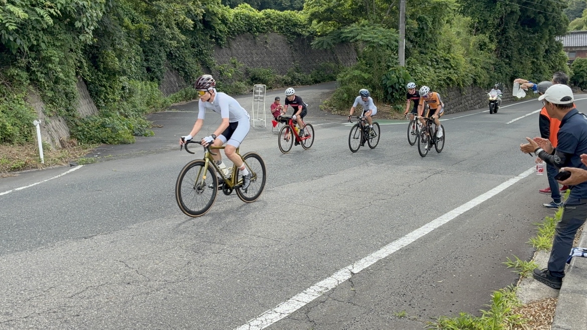 コース序盤の1分坂と言われる坂を上る選手たち。ここが補給ポイントです。